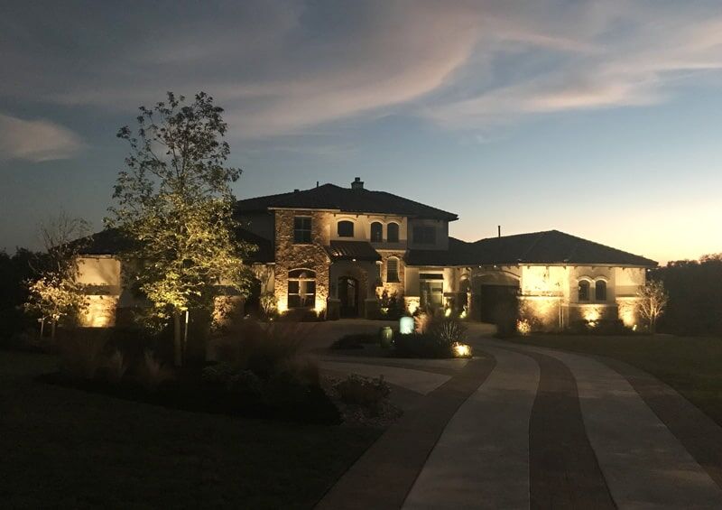 Beautiful front yard lit up with lights.